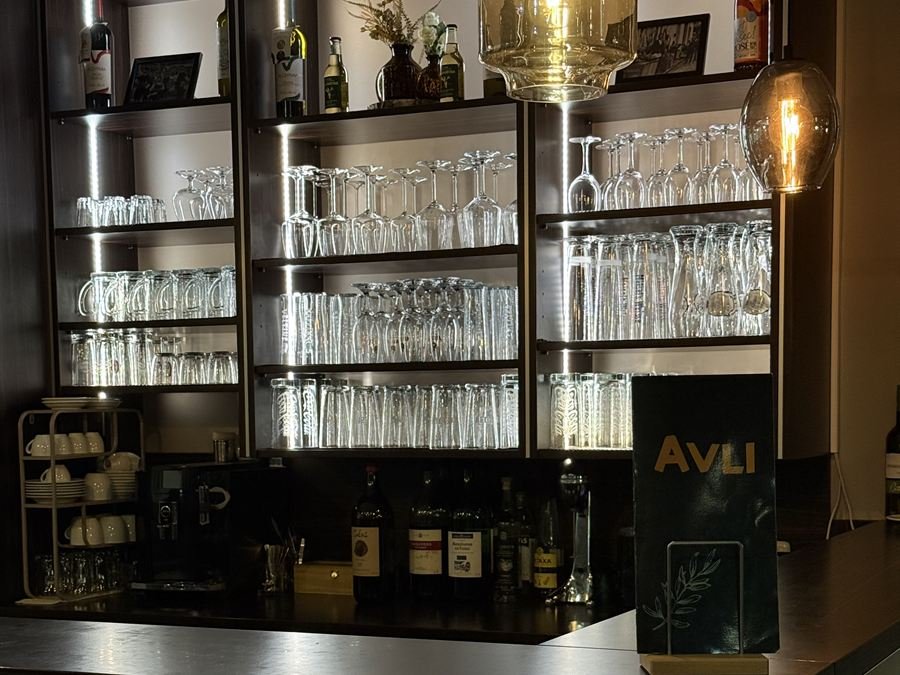 Die Bar des AVLI mit Gläsern, Flaschen und dem AVLI-Schild